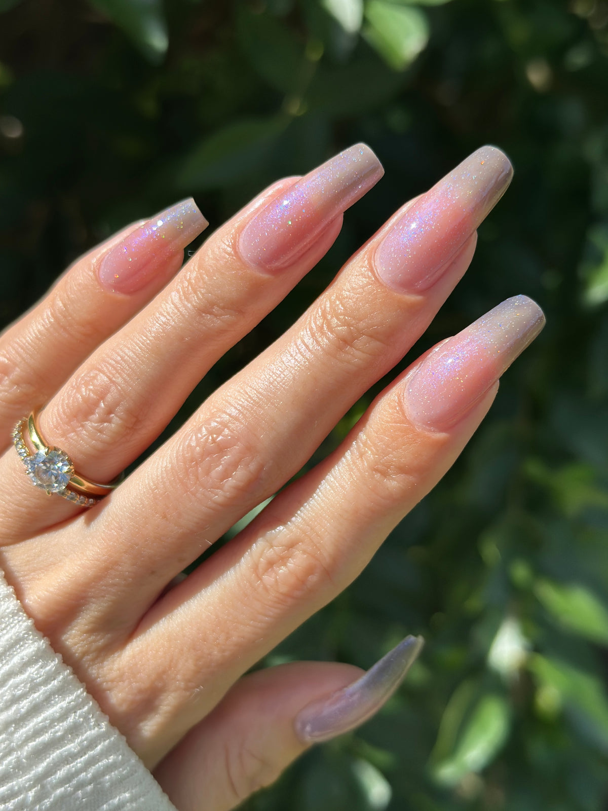 A manicured hand with a translucent shimmery nail polish.