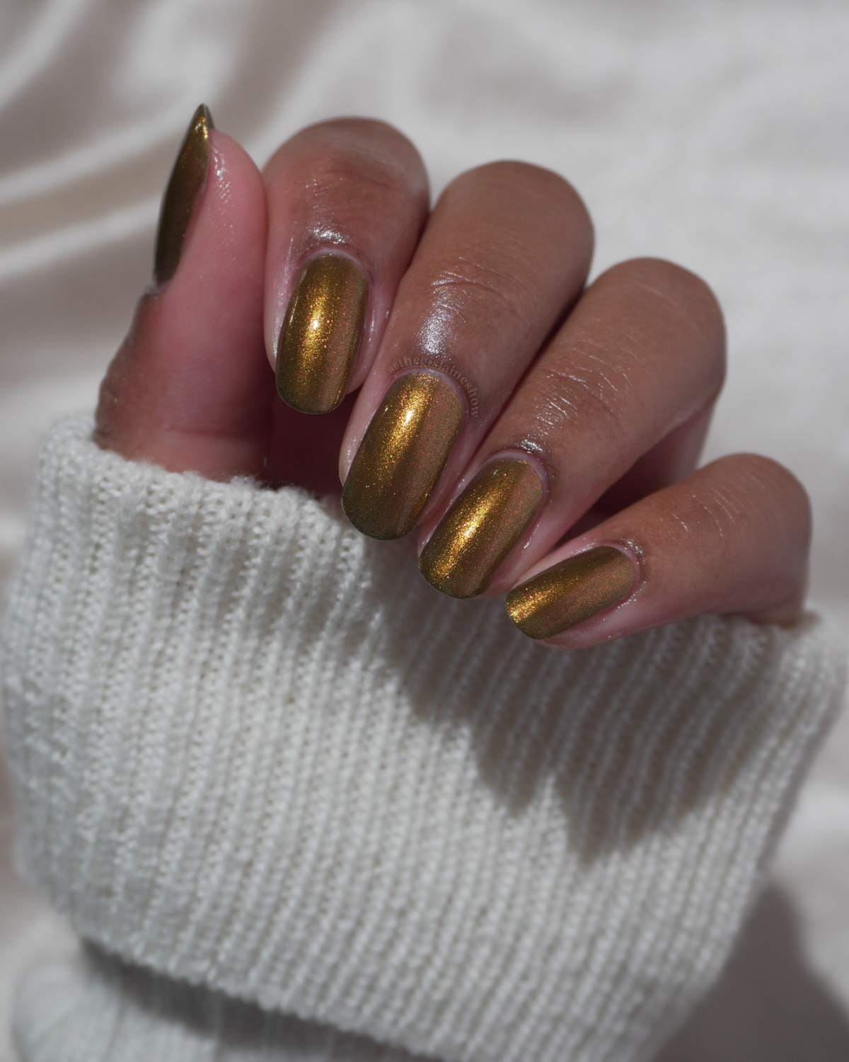 A hand with a copper shimmer manicure. 